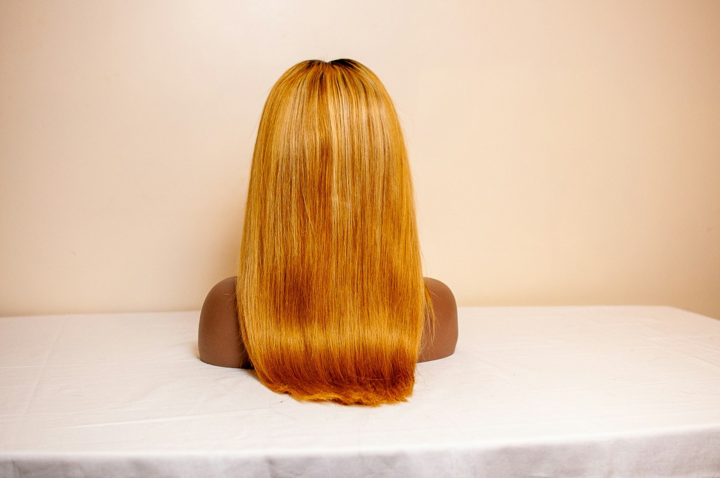 A honey-toned layered unit resting on a mannequin head